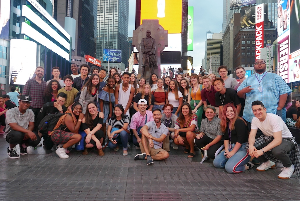 Group photo of students in Times Square at night